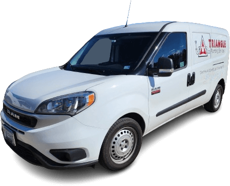 White Triangle Plumbing & Septic service van parked outside